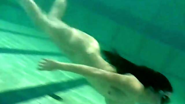 Beautiful naked girl swims in the pool