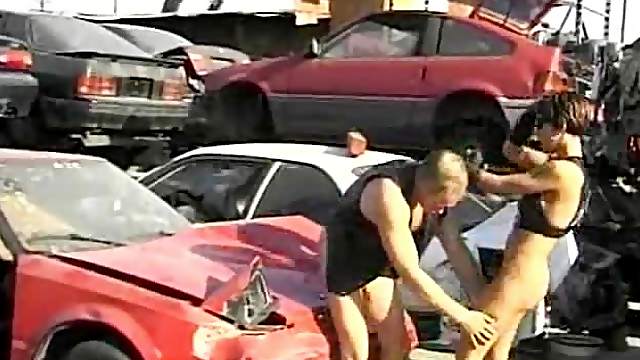 Hardcore in the junkyard with his leather slut